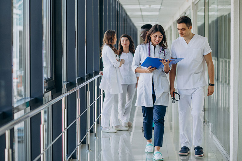 equipo-medicos-especialistas-jovenes-pie-pasillo-hospital_2